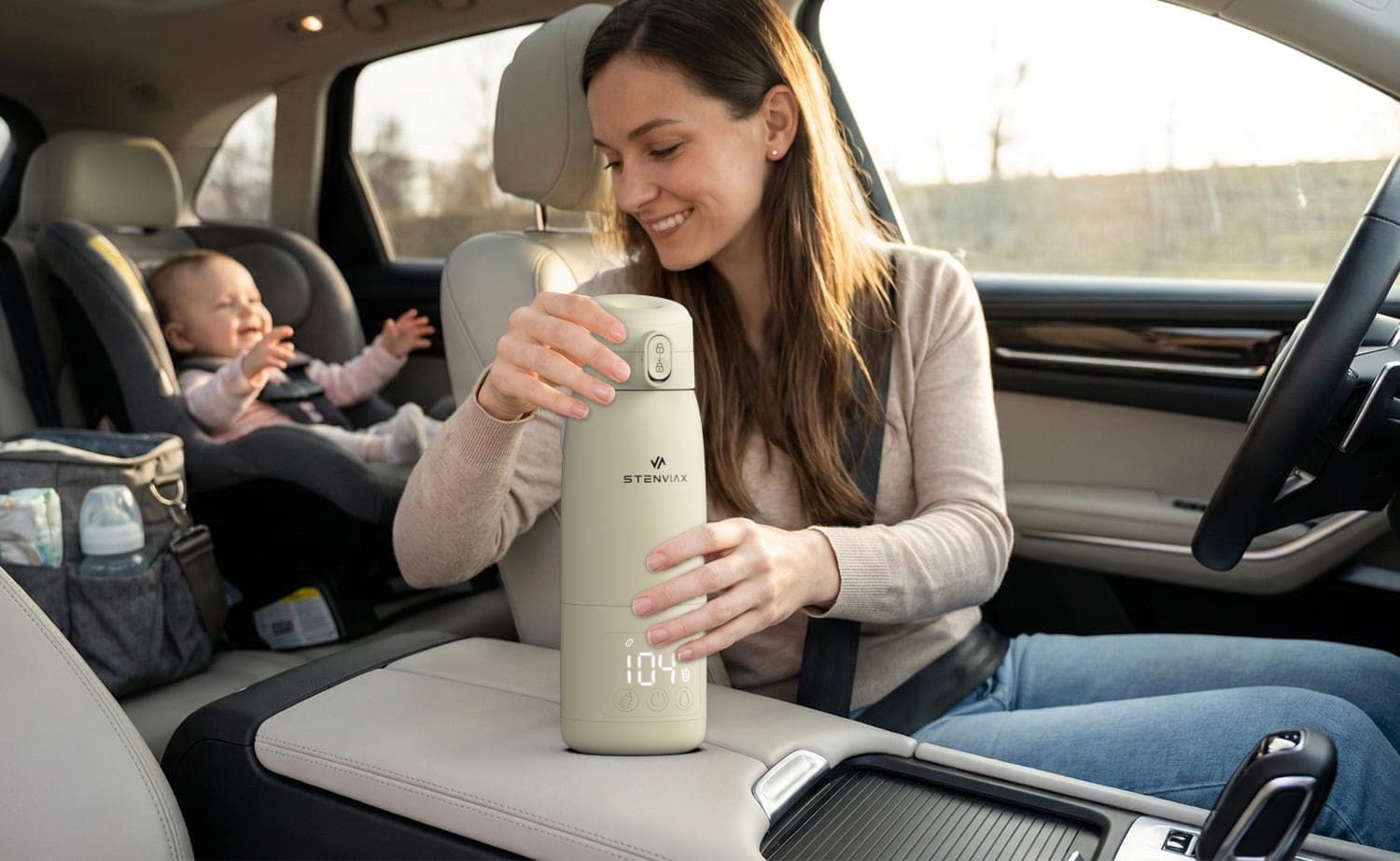 A parent lifting the warmer from the passenger seat, a baby laughing in the car seat behind
